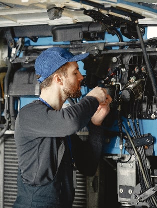 Mechanic performing engine repair and maintenance, focusing on diagnostics and performance testing at Route 40 Auto.