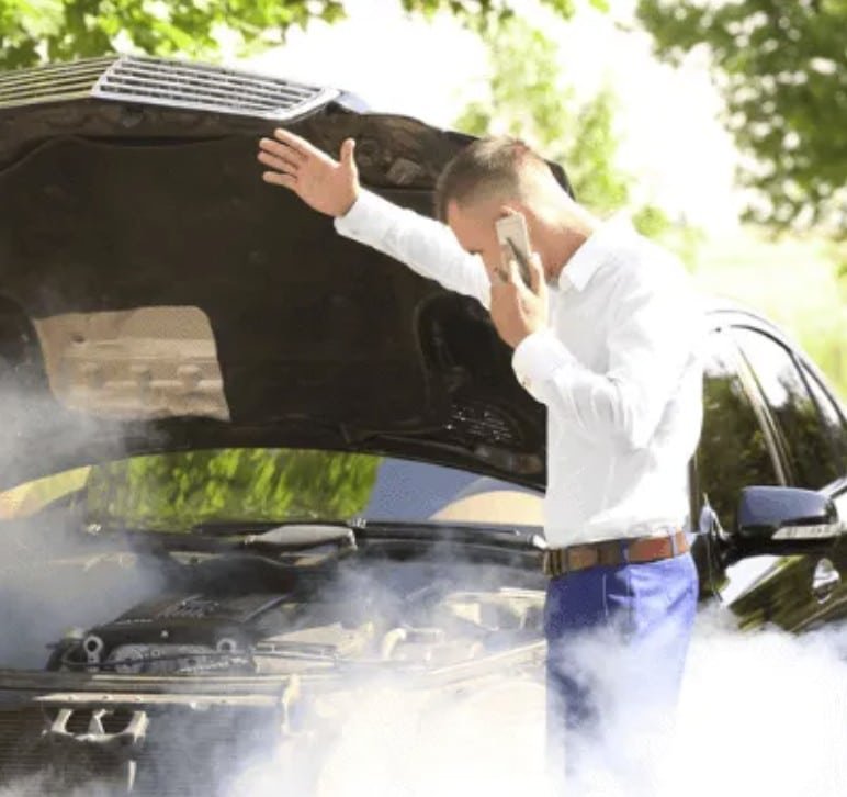 Vehicle emitting smoke from the exhaust on the side of the road, reflecting dangers of faulty catalytic converter Overheating engine and smoke with frustrated driver on phone, automotive repair concerns.